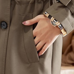 Damski zwężany trencz o długości midi z klapami