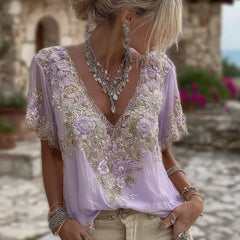 Damska koszulka z krótkim rękawem i dekoltem w serek, wykonana z mieszanki lnu i ozdobiona haftowanymi kwiatami