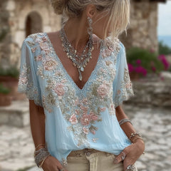 Damska koszulka z krótkim rękawem i dekoltem w serek, wykonana z mieszanki lnu i ozdobiona haftowanymi kwiatami