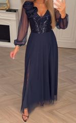 Sukienka z koronkowymi rękawami, cekinami i kwiatowymi zdobieniami.