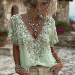 Damska koszulka z krótkim rękawem i dekoltem w serek, wykonana z mieszanki lnu i ozdobiona haftowanymi kwiatami