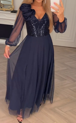 Sukienka z koronkowymi rękawami, cekinami i kwiatowymi zdobieniami.