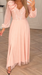 Sukienka z koronkowymi rękawami, cekinami i kwiatowymi zdobieniami.