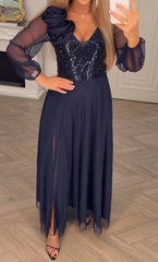 Sukienka z koronkowymi rękawami, cekinami i kwiatowymi zdobieniami.